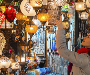 el-gran-bazar-de-estambul-mujer-explorando-puesto-de-lamparas