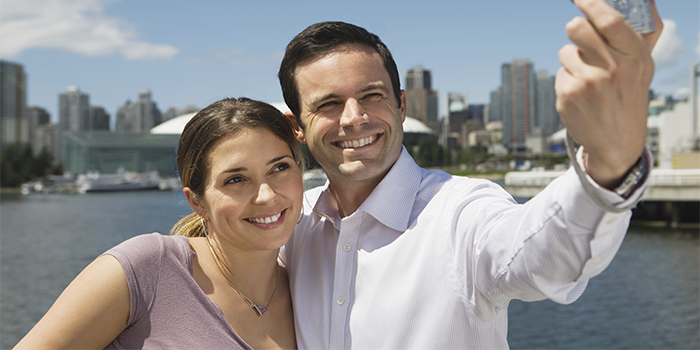lugares-para-visitar-en-vancouver-pareja-de-turistas-tomandose-selfier-con-ciudad-atras